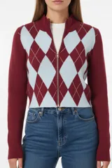 Campera de punto con cierre frontal, diseño de rombos en colores marrón y fucsia en el frente y mangas lisas de color marrón.
