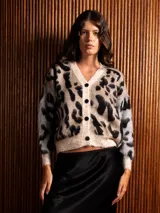 Saco corto de tejido peludito con estampado animal print grande, cuello en V y cierre frontal con botones. Presenta un diseño de bloques de color con mangas en tono contrastante.