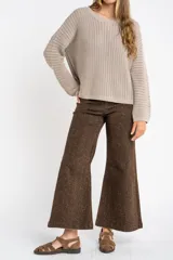 Sweater de punto texturado en color bordó con destellos de lurex, de corte holgado, cuello redondo y mangas largas.