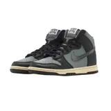Championes Nike Dunk High de corte alto, con diseño en combinación de cuero negro y gris. Presenta suela de goma en tono crema envejecido y detalle de dije metálico colgante en el cuello.
