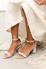 Sandalia de tacón cuadrado medio, confeccionada en tela tipo terciopelo color bordó, con tira delantera simple y pulsera ajustable al tobillo con hebilla metálica.