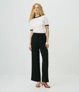 Pantalón wide leg de sastrería color negro, confeccionado en crepé, con cintura con pasacintos y corte de pernera ancha.