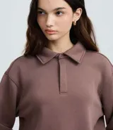 Saco cerrado de algodón con felpa, color bordó, con cuello polo, cierre frontal con botones, manga larga y puños y bajo ajustados.