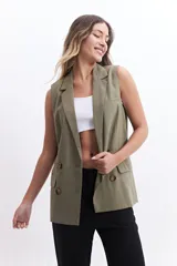 Chaleco color verde oliva con solapas clásicas, doble botonadura y bolsillos delanteros. Corte recto y sin mangas.