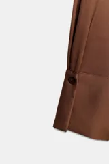 Vestido midi de viscosa color marrón, con escote cruzado en pico, manga larga con puños y falda evasé.