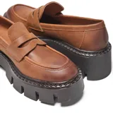 Mocasines de diseño urbano con capellada lisa y antifaz clásico, confeccionados en material símil cuero color camel. Presentan una plataforma alta estilo chunky con suela de goma dentada.