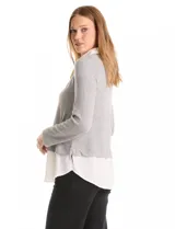 Buzo combinado de hilado fino color gris, con cuello en V y mangas largas. Presenta una pieza inferior y cuello tipo solapa en tela blanca que simula una camisa debajo.