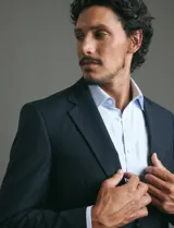 Traje de corte clásico compuesto por saco de dos botones y pantalón de vestir a juego. Diseño tradicional en color negro.