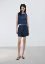 Top de algodón estilo denim, de corte recto y sin mangas con tirantes anchos, cuello redondo y detalle de ribetes contrastantes con costuras decorativas blancas en los bordes.