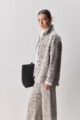 Sobrecamisa de corte relajado con estampado animal print, cuello camisero, cierre frontal con botones, hombros caídos y bolsillo plaqué en el pecho.