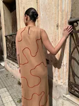 Vestido midi sin mangas color beige con estampado de líneas onduladas color ladrillo.