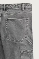 Bermuda relaxed fit color marrón con efecto lavado, cinco bolsillos, bolsillos frontales de carpintero y cierre frontal con cremallera y botón.