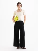 Top de punto morley color negro, con silueta ajustada al cuerpo, mangas cortas y escote redondo pronunciado.