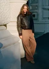 Pantalón jeans estilo wide leg de tiro medio color marrón claro, con diseño suelto, trabillas para cinto, cinco bolsillos y detalles de costuras en la cadera.
