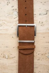 Cinto marrón de gamuza con hebilla metálica plateada.