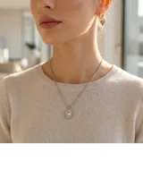 Collar de acero con cadena fina y dije ovalado que presenta un centro de circonia rodeado de nácar.