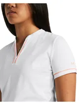 Polo de golf Under Armour de manga corta, color blanco con detalles en naranja neón en el escote en V. Confeccionado en tejido técnico transpirable, elástico y de secado rápido con protección solar UPF 50+.
