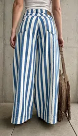 Jean estilo wide leg con diseño rayado en color celeste y blanco, de tiro alto y corte ancho en las piernas.