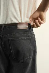 Jeans de corte recto en tono azul clásico con efecto lavado, tiro medio y diseño de cinco bolsillos con cierre frontal de botones.