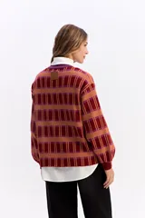 Sweater de punto con diseño de cuadros en tonos beige y crema, de silueta relajada, cuello redondo y mangas largas con puños elásticos.