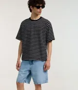 Bermuda de hombre de jean azul claro, corte slim, con cintura fija, cierre tradicional y bolsillos delanteros y traseros.