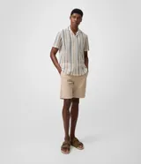 Bermuda masculina de sarga color beige con corte recto, bolsillos funcionales y trabillas para cinturón.