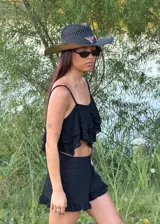 Top corto de tirantes finos en color blanco, con diseño de capas con terminación en punta y textura delicada en relieve.