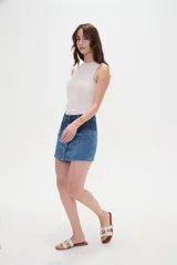 Minifalda de denim con diseño color block que combina dos tonos de azul, tiro alto y cierre frontal con hilera de botones metálicos.