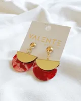 Aros colgantes con base dorada y pieza semicircular inferior de resina roja con efecto marmolado.