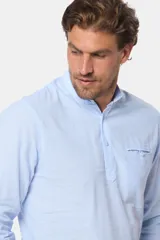 Camisa celeste de lino y algodón, de manga larga, corte slim, con cuello mao, medio abotonada y bolsillo en el pecho.