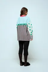 Sweater de punto con diseño geométrico y a rayas, de corte holgado y manga larga. Presenta un patrón combinado de lunares en las mangas, rombos en la parte superior y rayas verticales en el cuerpo.