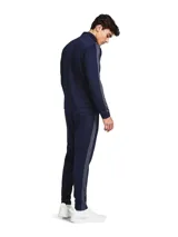 Conjunto deportivo Under Armour compuesto por una campera con cierre frontal y cuello alto, y un pantalón de jogging a juego. Ambas piezas presentan un diseño en color azul marino con detalles en gris oscuro y el logo de la marca estampado en el pecho y en el muslo.