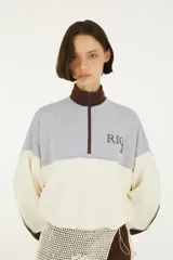 Buzo Farm Rio de diseño colour block en tonos celeste, blanco y marrón, con cuello alto, cierre medio y logo bordado en el pecho.