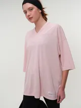 Remera deportiva de manga corta rosada, con escote en V y corte oversized de tejido dry fit.