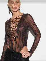 Body de manga larga confeccionado en tela translúcida con estampado animal print en tonos tierra. Presenta un escote profundo con cordones cruzados que generan un efecto corset y un corte de pierna alta.