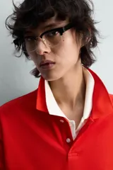 Polo de manga larga color rojo, confeccionado en tejido de algodón con estructura piqué, cuello solapa y cierre frontal de botonadura. Presenta aberturas laterales en el bajo.