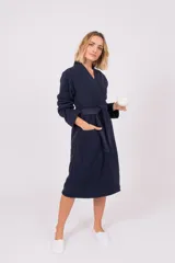 Bata de polar con cuello solapa, mangas largas y lazo ajustable en la cintura. Presenta bolsillos frontales y un largo midi.