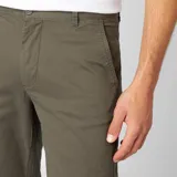Pantalón tipo chino de corte slim, color verde oliva, con cierre de botón y cremallera, bolsillos laterales y traseros.