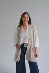 Chaleco largo abierto de tejido de punto, color visón, con bolsillos frontales aplicados y diseño sin mangas.