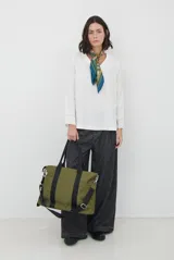 Blusa de corte recto y holgado, color blanco, con escote en V y mangas largas con detalle de costura en los puños.