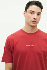 Remera de manga corta color ladrillo con cuello redondo y logo de la marca estampado en el pecho.