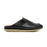 Zueco casual Korium Confort modelo Suria, color negro, confeccionado en cuero con detalles de recortes y costuras visibles en contraste. Cuenta con tira ajustable con velcro en el empeine y suela plana color beige.