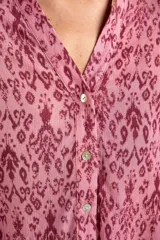 Camisa de manga corta con estampado abstracto en tonos rosa y borgoña. Tiene cuello camisero, cierre frontal con botones y corte oversize.