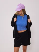 Gorro de visera color lila, estilo dad hat, de lona lavada con bordado frontal en blanco que dice "RUSTY AUSTRALIA MERMAID BEACH".