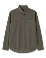 Camisa de manga larga confeccionada en pana de algodón, color verde oliva. Presenta cuello con botones, cierre frontal abotonado y un bolsillo en el pecho con etiqueta pequeña.