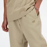Pantalón de jogging color beige, de corte clásico y cómodo, con cintura elástica y cordón regulable, bolsillos laterales y posterior, y bajo inferior elástico.