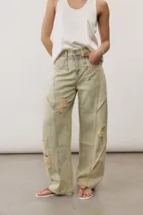 Pantalón de jean de corte wide leg, tiro medio y lavado claro con efecto desgastado. Presenta diseño de múltiples paneles con costuras pespunteadas verticales y roturas en ambas piernas.