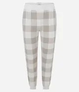 Conjunto de pijama de dos piezas confeccionado en tricot liviano. Incluye una remera de manga larga con escote redondo y un pantalón tipo jogger con cintura elástica y puños ajustados. Presenta un estampado de cuadros en tonos beige y blanco.