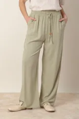 Pantalón ancho color verde claro, de lino y rayón, con cintura elastizada ajustable con cordón y bolsillos laterales.