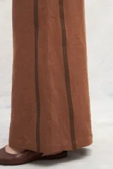 Pantalón marrón de lino, corte jeanero, con bolsillos plaque traseros y cintas laterales a contratono.